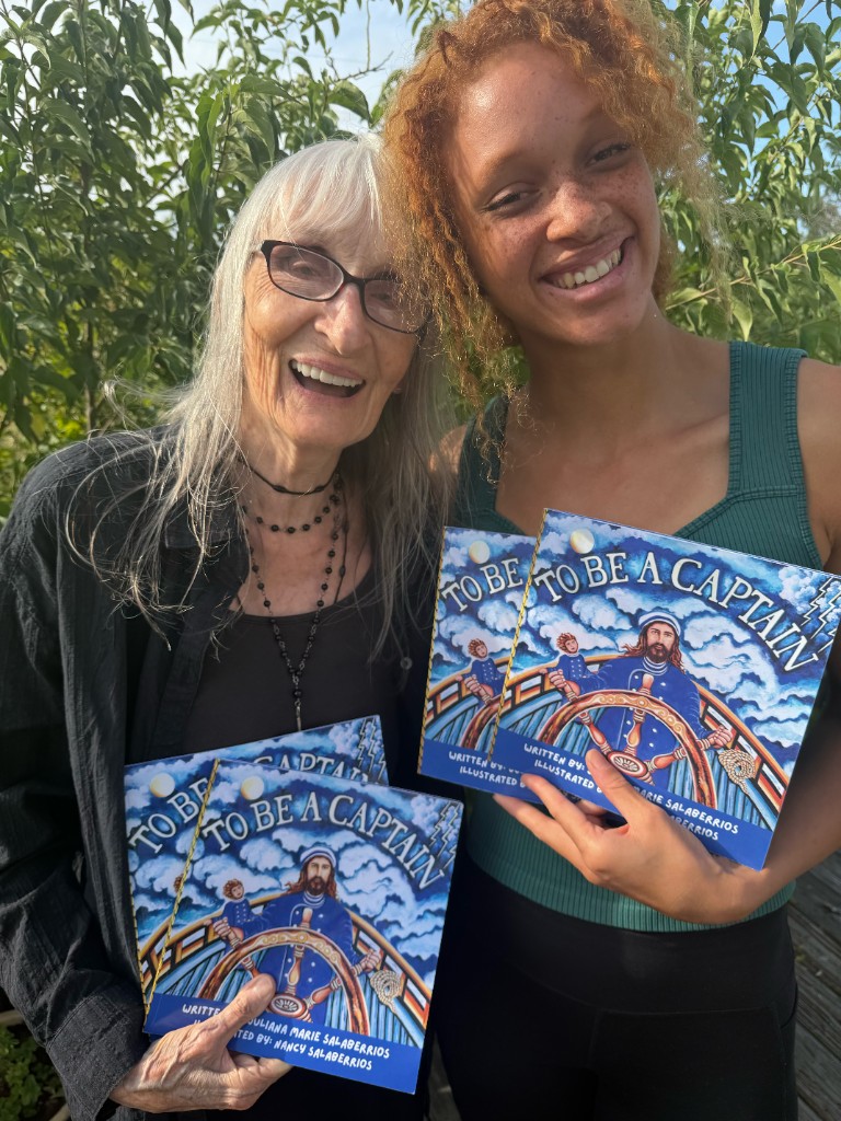 Juliana Marie Salaberrios and Nancy Salaberrios smiling and holding copies of To Be A Captain